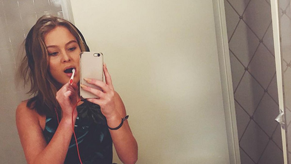 Zara Larsson borstar tänderna och tar en selfie. 